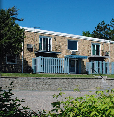 a brick building with a white fence in front of it